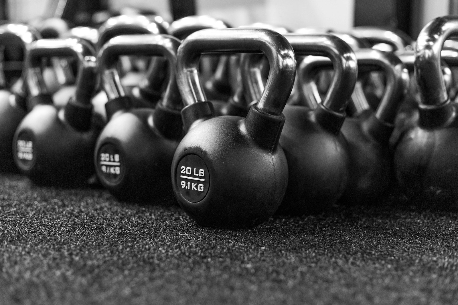 Kettlebells alineadas en el piso de un gimnasio